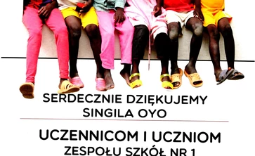 Dyplom z podziękowaniem dla uczniów . Na zdjęciu dzieci czarnoskóre jedzące pączki.