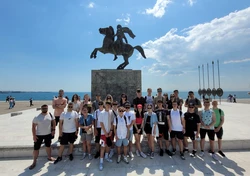 grupa młodzieży, w tle greckie nadmorskie miasteczko