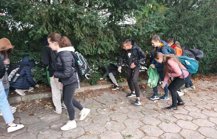 Grupa chłopców trzymająca oponę i worki z zebranymi odpadami.